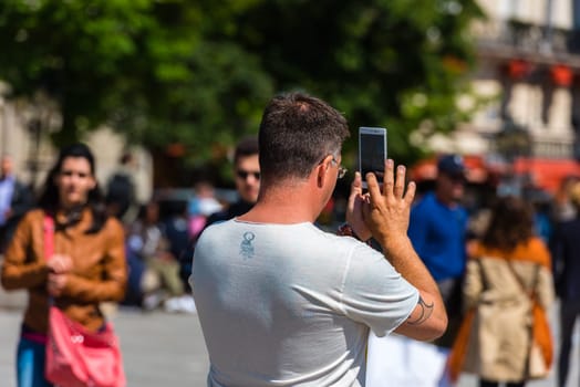 FRANCE, PARIS - JUNE 01: Man taking pictures on the street of a town on June 01, 2015