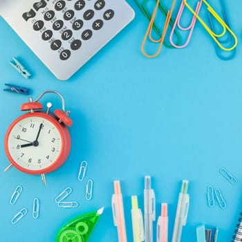 Square Creative flat lay top view back to school concept with alarm clock color school and office supplies on bright turquoise paper table frame background with copy space, template for text or design