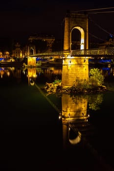 Old Passerelle du College bridge over Rhone river in Lyon, France at night