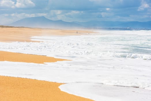 Long Sand Atlantic Beach with ocean waves. The Gironde Department, France. Shot with a selective focus
