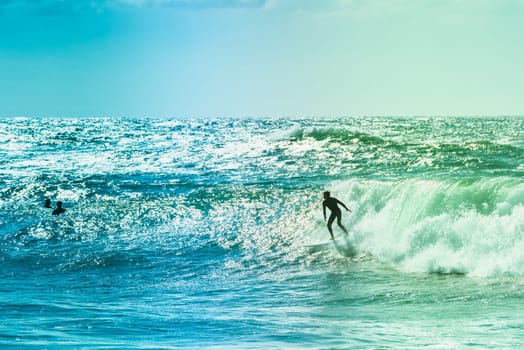 Extreme surfers riding some waves on the sea in France