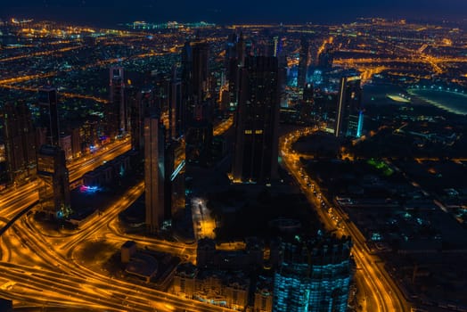 Dubai downtown night scene with city lights. Top view from above