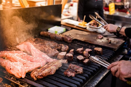 Some excellent pieces of Argentinian beef on a charcoal grill being prepared at open kitchen street food festival in Ljubljana, Slovenia