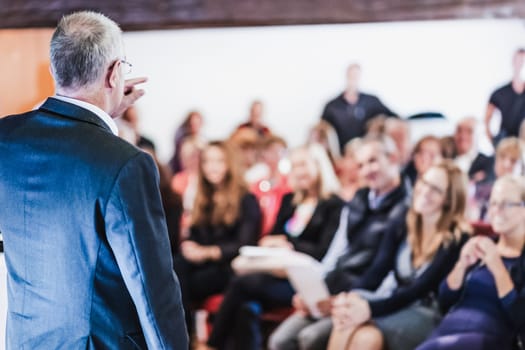 Business man leading a business workshop. Corporate executive delivering a presentation to his colleagues during meeting or in-house business training. Business and entrepreneurship concept.