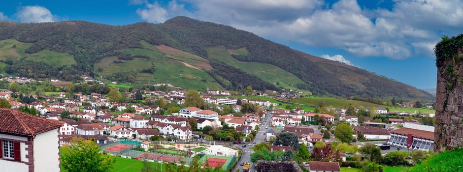 Saint Jean Pied de Port. A lot of houses and a green tennis court. The houses are mostly white and brown