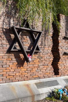 Czestochowa, Poland - October 18, 2024: Monument to Jews of Czestochowa, commemorates 40,000 Jews murdered in the Treblinka death camp. Star of David made of railway rails, crack in red brick wall