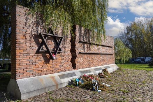 Czestochowa, Poland - October 18, 2024: Monument to Jews of Czestochowa, commemorates 40,000 Jews murdered in the Treblinka death camp. Star of David made of railway rails, crack in red brick wall