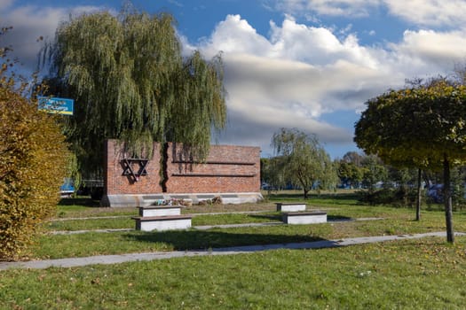 Czestochowa, Poland - October 18, 2024: Monument to Jews of Czestochowa, commemorates 40,000 Jews murdered in the Treblinka death camp. Star of David made of railway rails, crack in red brick wall