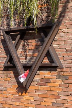 Czestochowa, Poland - October 18, 2024: Monument to Jews of Czestochowa, commemorates 40,000 Jews murdered in the Treblinka death camp. Star of David made of railway rails, crack in red brick wall