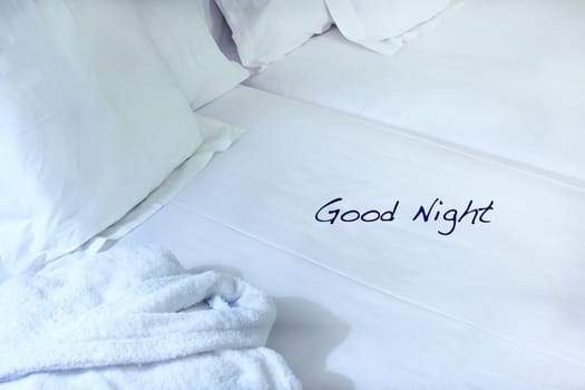 Night scene in hotel room: prepared fresh bed and bathrobe