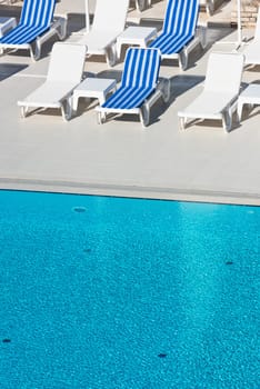 Hotel Poolside Chairs near a swimming pool. Summer shot