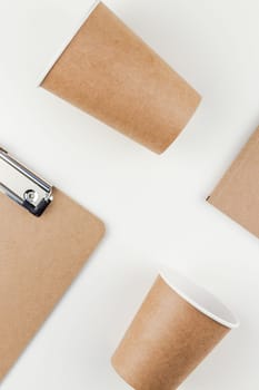 Creative top view flat lay of workspace desk styled recycled brown design office supplies and coffee cups with copy space white table background minimal eco style. Concept of environmental protection