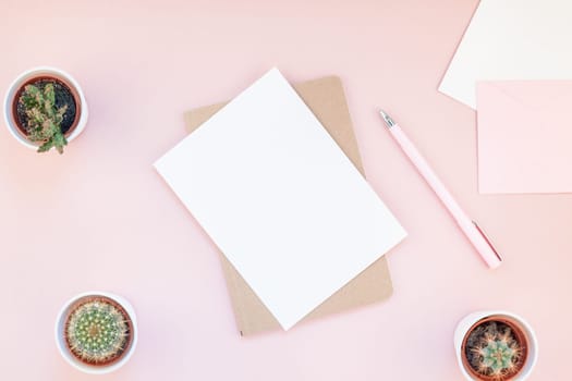 Top view flat lay of workspace desk styled design office supplies and cactuses succulents with copy space millennial pink color paper background minimal style. Template for feminine blog social media