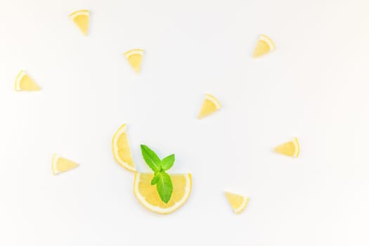 Creative flatlay overhead top view citrus lemon slices and mint herbs leaves white table background with copyspace. Hot summer refreshment lemonade concept. Beverage ingredients arranged