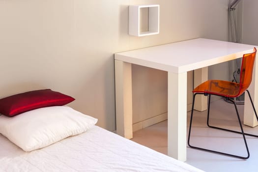 Bed, table and chair, scene in apartments room. Horizontal shot