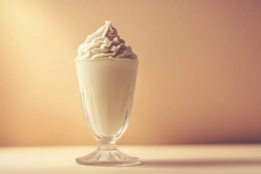 The elegant milkshake glass stands tall, filled with creamy, chilled liquid and topped with a swirl of whipped cream, all set against a softly lit, warm background.