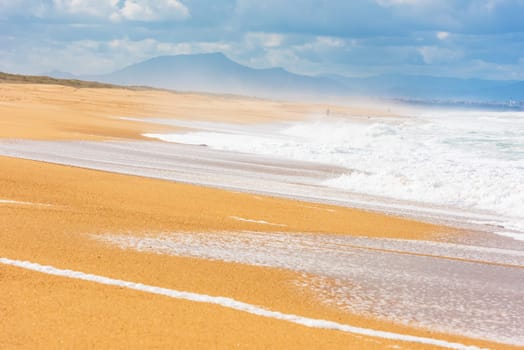 Long Sand Atlantic Beach with ocean waves. The Gironde Department, France. Shot with a selective focus