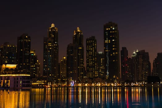 Night cityscape of Dubai city, United Arab Emirates. Reflections in the water