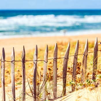 Wooden fence on an Atlantic beach in France, The Gironde Department. Square filtered Shot with a selective focus
