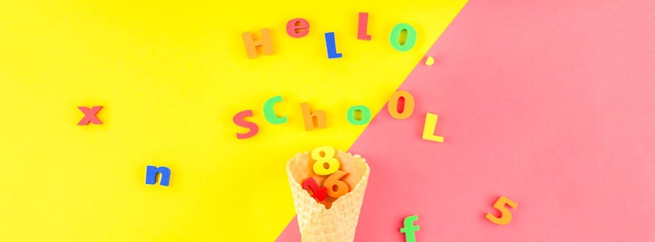 Creative flat lay back to school concept with waffle cone and welcome letters message on bright yellow and pink paper background with copy space, template for text or design. Long wide banner