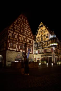 Illuminated historic half-timbered houses in the picturesque old town of Rothenburg ob der Tauber in the Franconia region of Germany