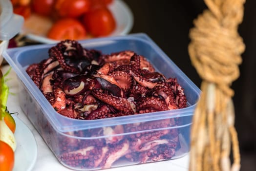 Cooked octopus parts in a box ready for serving in a restaurant