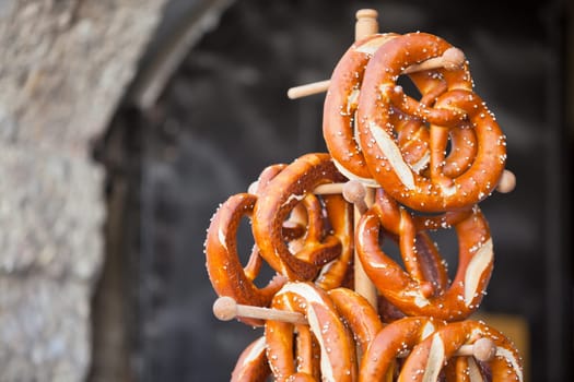 Pretzels - traditional german snacks are hanging on the wooden stand