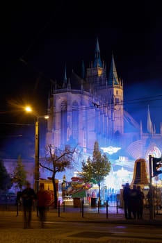 Cathedral square in Erfurt brightly illuminated by rides during the Oktoberfest with the cathedral in the background