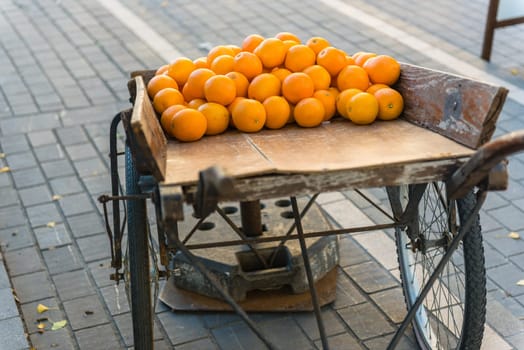 Fresh oranges on vintage wooden cart in the town