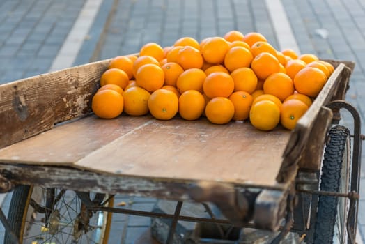 Fresh oranges on vintage wooden cart in the town