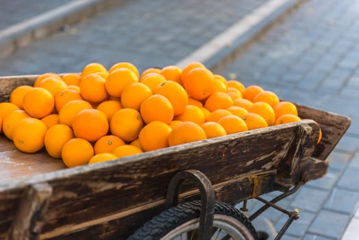Fresh oranges on vintage wooden cart in the town