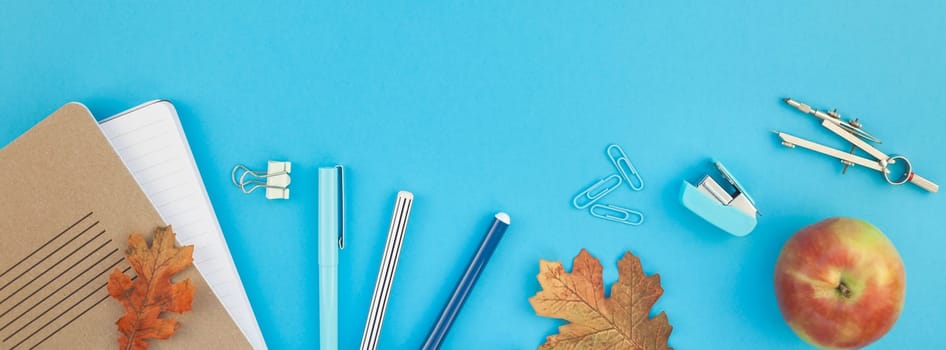 Creative flat lay top view back to school concept with color school and office supplies on bright turquoise paper table frame background with copy space, template for text or design. Long wide banner