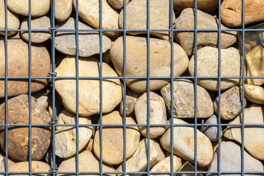 metallic basket net filled by natural stones as a fence