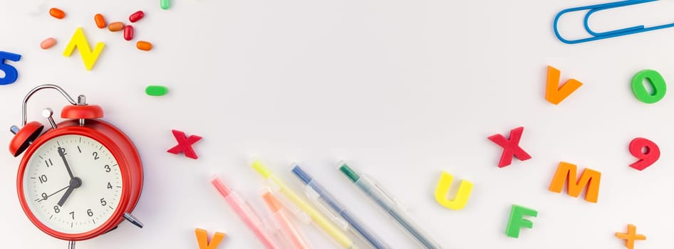 Long wide banner back to school concept with alarm clock, color school and office supplies on white table background with copy space, frame, template for text or design
