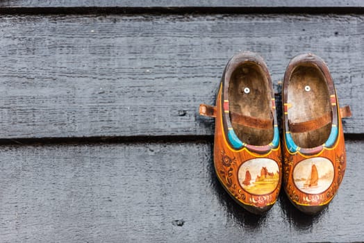 Traditional dutch wooden shoes hanging at a wall. Background