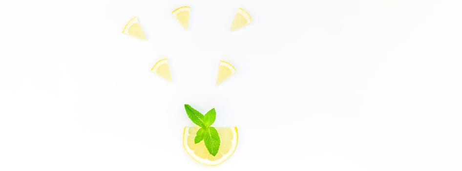 Long wide banner top view citrus lemon slices and mint herbs leaves white table background with copyspace. Hot summer refreshment lemonade concept. Beverage ingredients arranged