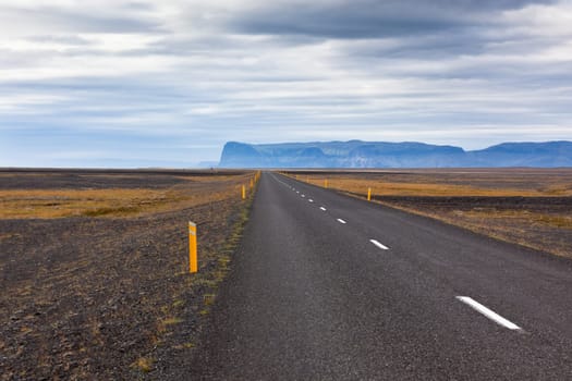 Highway through Iceland landscape at overcast day. Horizontal shot