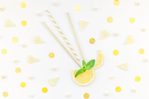 Creative flatlay overhead top view citrus lemon slices and mint herbs leaves white table background with copyspace. Hot summer refreshment lemonade concept. Beverage ingredients arranged with straws