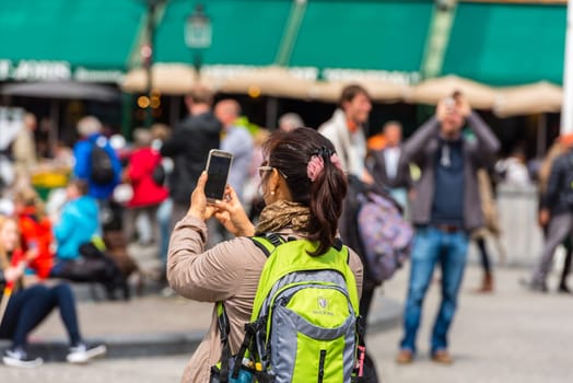 BELGIUM, BRUGES - MAY 22: Woman is taking pictures on the street of Bruges on May 22, 2015