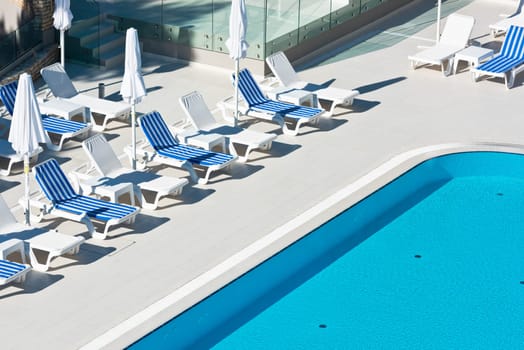 Hotel Poolside Chairs near a swimming pool. Summer shot