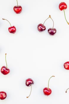 Creative top view of fresh ripe cherry pattern layout with copy space isolated on white background in minimal style. Concept of summer fun and healthy eating. Template for your text or food design
