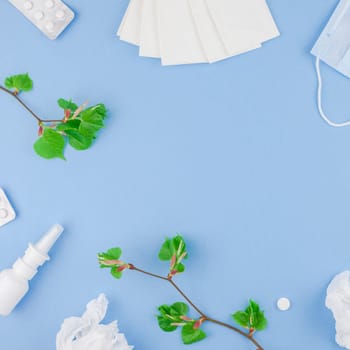 Creative flat lay concept of seasonal spring pollen allergy with napkins, pills, face mask, drops in a bottle and fresh green sprouts with buds. Square copy space background minimal style, template