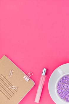 Creative top view flat lay of workspace desk styled design office supplies and cup of tea with copy space on a bright pink color paper background minimal style. Template for feminine blog social media