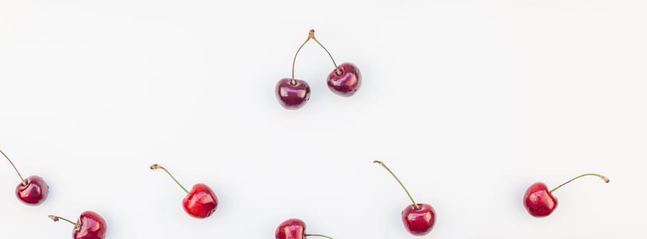 Long wide banner of fresh ripe cherry pattern layout with copy space isolated on white background in minimal style. Concept of summer fun and healthy eating. Template for your text or food design