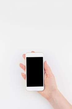Woman hand with pastel manicure polish holding smartphone isolated on white background with copy space in minimalism style. Template mock up for feminine blog social technological media
