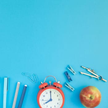 Square Creative flat lay top view back to school concept with alarm clock color school and office supplies on bright turquoise paper table frame background with copy space, template for text or design