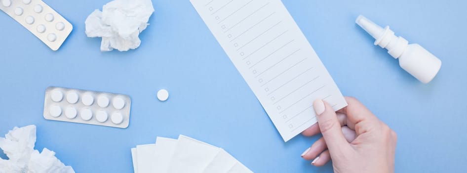 Creative flat lay concept of seasonal spring allergy with napkins, pills, drops in a bottle and a female hand with copy space long wide banner minimal style, template for text