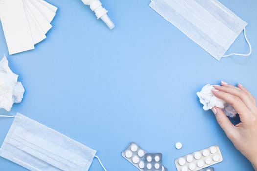 Creative flat lay concept of seasonal spring allergy with napkins, pills, face mask, drops in a bottle and a female hand with copy space background minimal style, template for text