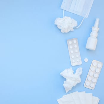 Creative flat lay concept of seasonal spring allergy with napkins, pills, face mask and drops in a bottle with copy space square background minimal style, template for text