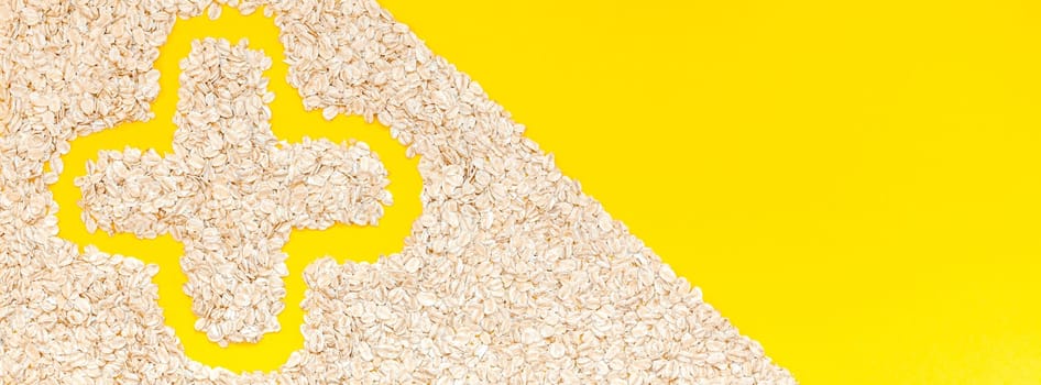 Creative flat lay concept top view of oatmeal flakes for healthy and vegetarian organic food for breakfast on a bright yellow color paper long wide banner with copy space in minimal style